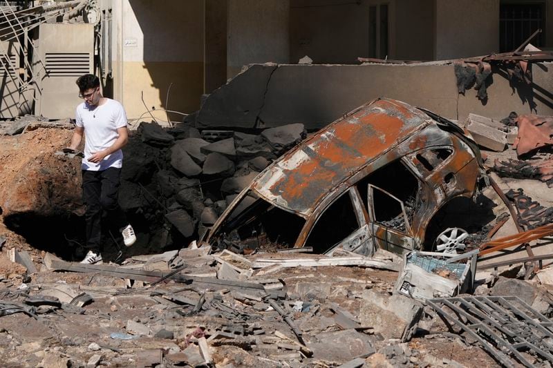 A man walks on rubble at the site of an Israeli airstrike in Beirut's southern suburbs, Sunday, Sept. 29, 2024. (AP Photo/Hassan Ammar)