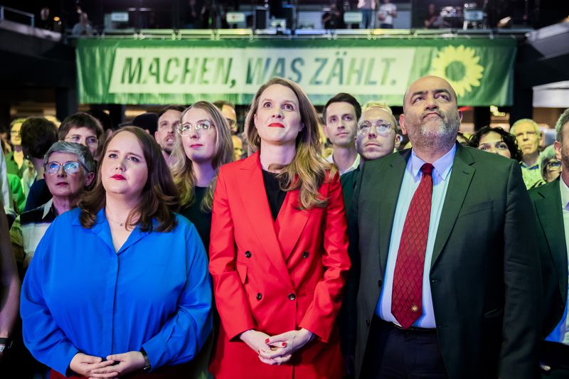 From left, Ricarda Lang, Federal Chairperson of Bündnis 90/Die Grünen, Terry Reintke, the Greens' lead candidate for the 2024 European elections, and Omid Nouripour, Federal Chairperson of Bündnis 90/Die Grünen, react to the first projections at the Greens' election party in the Columbiahalle, in Berlin, Sunday June 9, 2024. (Christoph Soeder/dpa via AP)