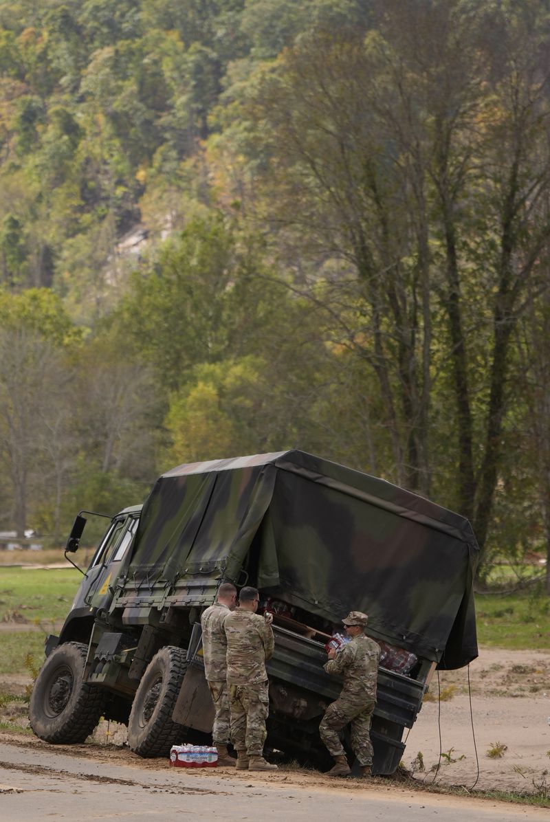 North Carolina National guardsman unload water in the aftermath of Hurricane Helene, Thursday, Oct. 3, 2024, in Pensacola, N.C. (AP Photo/Mike Stewart)