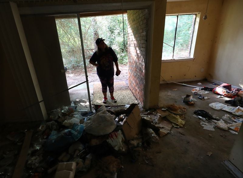 A Decatur resident looks into an apartment at The Village at Kensington in September 2022 where the windows are all broken out and trash litters the floor. Across Georgia, high rents and a vanishing number of affordable homes continue to put strains on renters. (Curtis Compton / Curtis Compton@ajc.com)