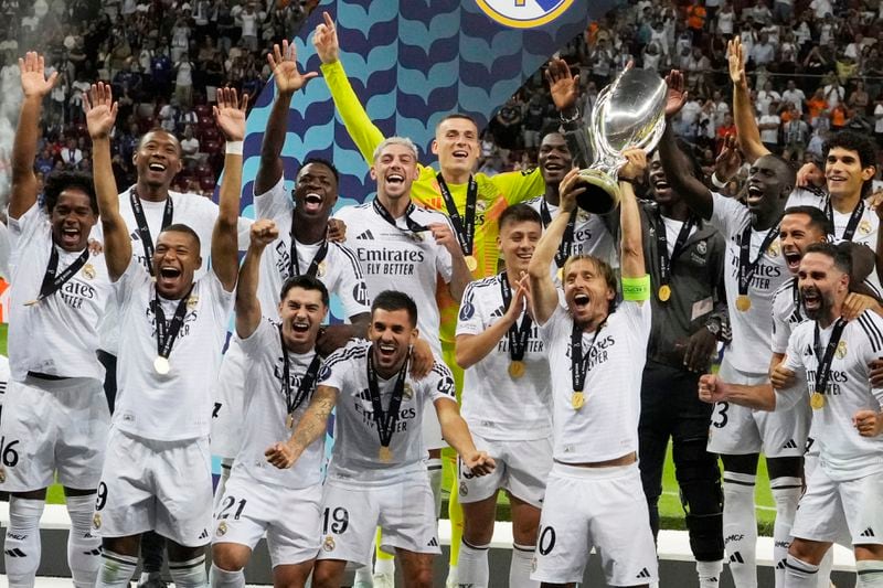 Real Madrid's team members celebrate with the trophy as they won the UEFA Super Cup Final soccer match between Real Madrid and Atalanta at the Narodowy stadium in Warsaw, Poland, Wednesday, Aug. 14, 2024. (AP Photo/Czarek Sokolowski)