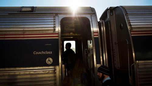 FILE - Passengers board an Amtrak train heading to New Orleans from Atlanta on Nov. 23, 2016. The federal government sued Norfolk Southern railroad on Tuesday, July 30, 2024, over chronic delays for Amtrak between New York and New Orleans. (AP Photo/David Goldman, File)
