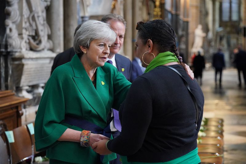 FILE - Former Prime Minister Theresa May, left and community volunteer Claire Walker speak before the Grenfell fire memorial service at Westminster Abbey, in remembrance of those who died in the Grenfell Tower fire in 2018, in London, Tuesday, June 14, 2022. (Jonathan Brady/Pool via AP, File)