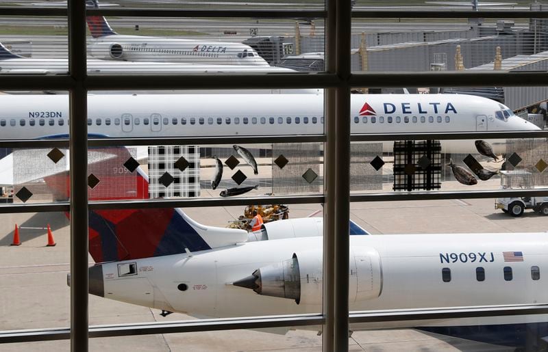 FILE - In this Monday, Aug. 8, 2016, file photo, Delta Air Lines planes are parked at Ronald Reagan Washington National Airport, in Washington.  (AP Photo/Carolyn Kaster, File)