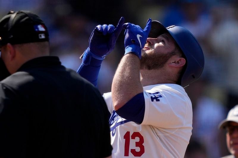 Los Angeles Dodgers' Max Muncy, right, gestures as he scores after hitting a solo home run during the eighth inning of a baseball game against the Cleveland Guardians, Sunday, Sept. 8, 2024, in Los Angeles. (AP Photo/Mark J. Terrill)