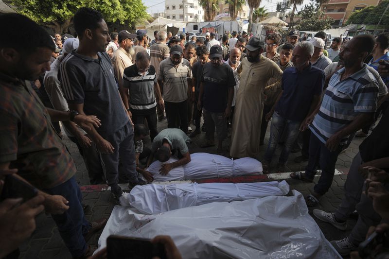 Palestinians mourn relatives killed in the Israeli bombardment of the Gaza Strip, at a hospital in Deir al-Balah, Tuesday, Aug. 27, 2024. (AP Photo/Abdel Kareem Hana)