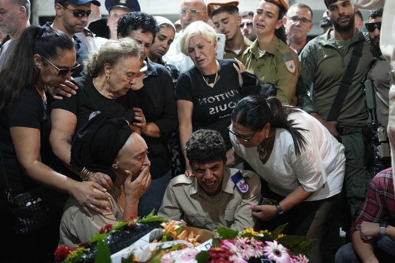 Relatives of Petty Officer 1st Class David Moshe Ben Shitrit, who was killed on a Hezbollah attack, mourn during his funeral at the Mount Herzl military cemetery in Jerusalem, Sunday, Aug. 25, 2024. (AP Photo/Ohad Zwigenberg)