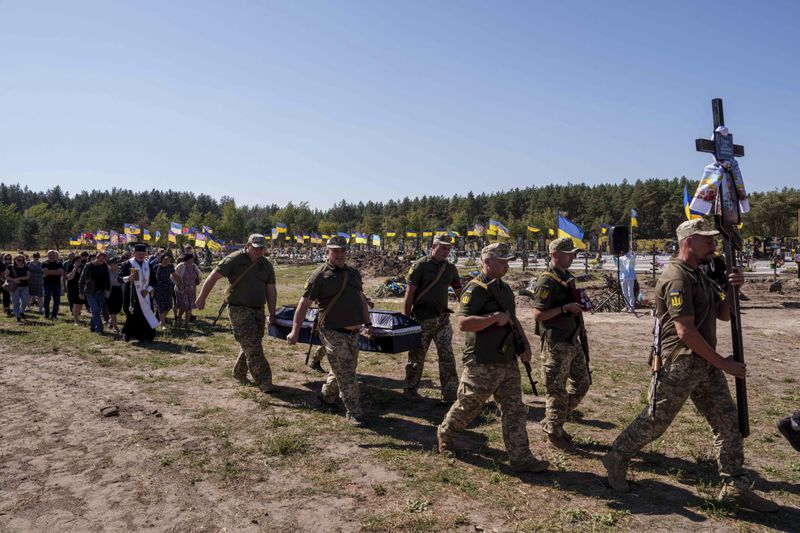 Ukrainian servicemen carry the coffin of their comrade Serhiy Dondiuk, killed in a Russian rocket attack at a Ukrainian military academy, during the funeral ceremony in Poltava, Ukraine, Saturday Sept. 7, 2024. (AP Photo/Evgeniy Maloletka)