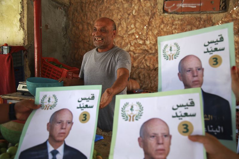 Supporters of Tunisian President and candidate for re-election Kais Saied meet with residents of a neighbourhood during a campaign tour, in Ariana, Tunisia, Thursday, Sept. 26, 2024. (AP Photo/Anis Mili)