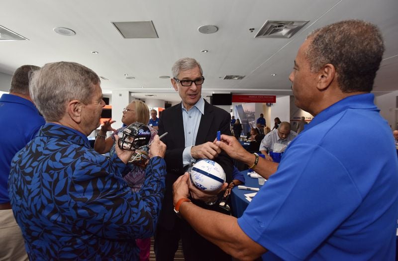 Georgia State University President Mark Becker (center) signs an autograph for guests during the 2019 Football Kickoff Luncheon at Georgia State Stadium on Wednesday, Aug. 14, 2019. HYOSUB SHIN / HYOSUB.SHIN@AJC.COM