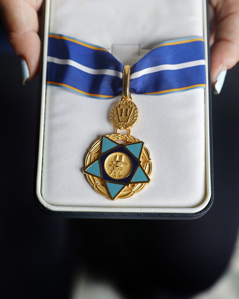 Pamela Yarosz holds the 9/11 Medal of Valor that was given to her brother and New York firefighter Christopher Michael Mozzillo, who died in the 9/11 attacks, Saturday, Sept. 7, 2024, in Freehold, N.J.. (AP Photo/Noah K. Murray)