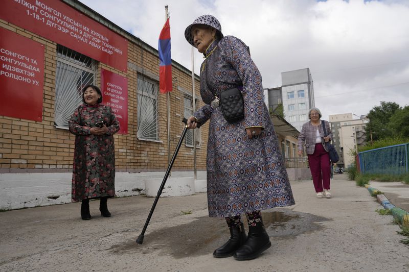 An elderly Mongolian woman arrives to vote at a polling station in Ulaanbaatar, Mongolia, Friday, June 28, 2024. Voters in Mongolia are electing a new parliament on Friday in their landlocked democracy that is squeezed between China and Russia, two much larger authoritarian states. (AP Photo/Ng Han Guan)
