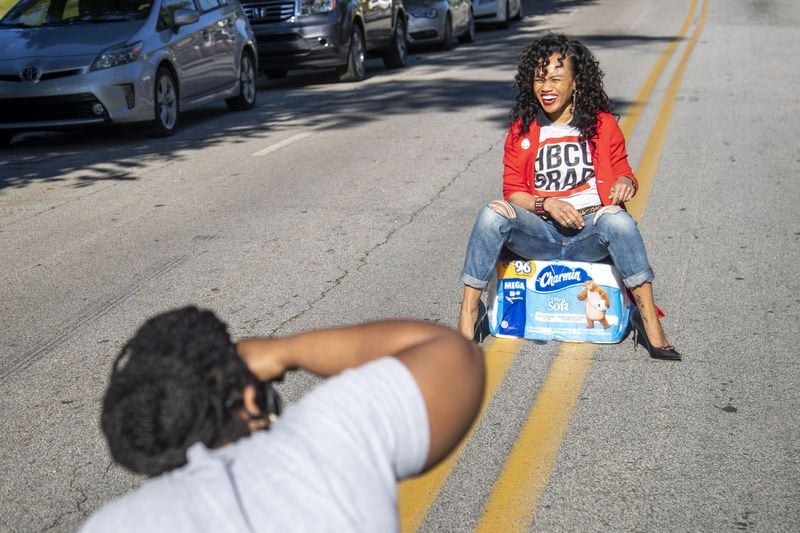 Jennifer DeBarr laughs as she gets her photo taken by Melissa Alexander (foreground) during a pull-up portrait session in Atlanta’s West End community, Friday, May 1, 2020. DeBarr brought the toilet tissue as a prop because she wanted to “commemorate this whole thing,” she said in reference to the COVID-19 pandemic. ALYSSA POINTER/ALYSSA.POINTER@AJC.COM