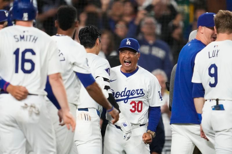 Los Angeles Dodgers designated hitter Shohei Ohtani (17) celebrates with manager Dave Roberts (30) after hitting a grand slam during the ninth inning of a baseball game against the Tampa Bay Rays in Los Angeles, Friday, Aug. 23, 2024. The Dodgers won 7-3. Will Smith, Tommy Edman, and Max Muncy also scored. (AP Photo/Ashley Landis)