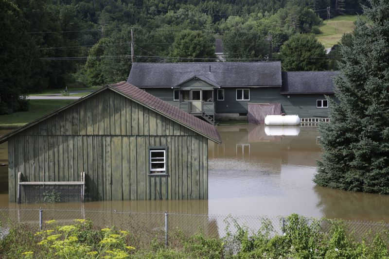 Water floods the lower level of homes, Thursday, July 11, 2024, in Waterbury, Vt. (AP Photo/Hasan Jamali)