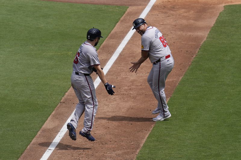 Atlanta Braves' Travis d'Arnaud, left, celebrates his three-run home run with third base coach Matt Tuiasosopo during the sixth inning of a baseball game against the San Diego Padres, Sunday, July 14, 2024, in San Diego. (AP Photo/Gregory Bull)