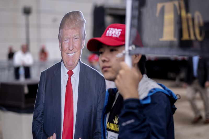 A supporter walks past a cardboard cutout of Republican presidential nominee former President Donald Trump before a campaign rally at the Mohegan Sun Arena at Casey Plaza in Wilkes-Barre, Pa., Saturday, Aug. 17, 2024. (AP Photo/Laurence Kesterson)