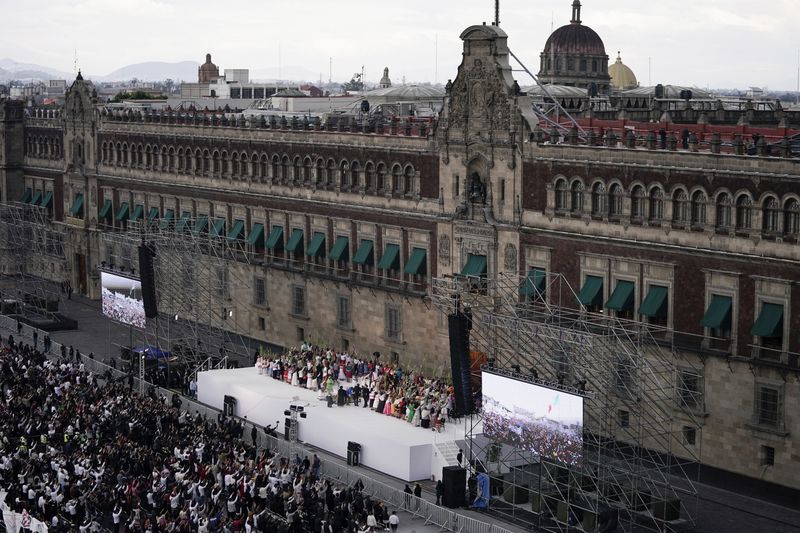 President Claudia Sheinbaum waves to Indigenous women during a rally in the Zócalo, Mexico City's main square, on her inauguration day, Tuesday, Oct. 1, 2024. (AP Photo/Aurea Del Rosario)