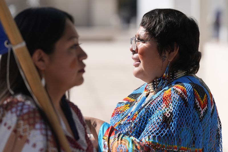 Loveena Watahomigie, left, and Zoe Perry pause in front of U.S. District Court as they join other members of the Hualapai Tribe gathered to try to persuade a federal judge to extend a temporary ban on exploratory drilling for a lithium project Tuesday, Sept. 17, 2024, in Phoenix. (AP Photo/Ross D. Franklin)