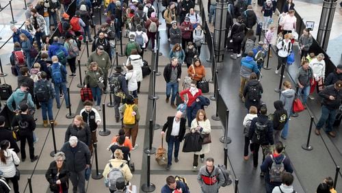 FILE - Passengers wait in a security line at Denver International Airport on Wednesday, Feb. 22, 2023. Consumer advocates on Tuesday criticized a court decision to hold up a Biden administration rule that requires airlines to more clearly disclose fees for baggage and changing a ticket. (AP Photo/Thomas Peipert, File)