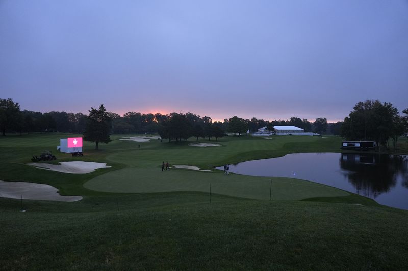 The sun rises over the 14th hold before the start of a Solheim Cup golf tournament foursomes match at Robert Trent Jones Golf Club, Friday, Sept. 13, 2024, in Gainesville, VA. (AP Photo/Chris Szagalo)