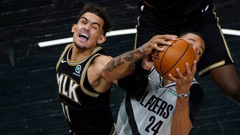 Hawks guard Trae Young (11) and Portland Trail Blazers forward Norman Powell (24) battle for a rebound in the second half Monday, May 3, 2021, in Atlanta. (John Bazemore/AP)