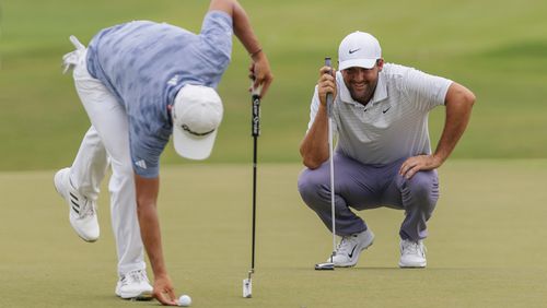 Scottie Scheffler shares a laugh with Collin Morikawa on the 18th green during the third round of the Tour Championship golf tournament, Saturday, Aug. 31, 2024, in Atlanta. (AP Photo/Jason Allen)