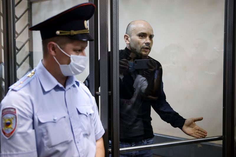 FILE - Andrei Pivovarov, former head of the Open Russia opposition group, gestures inside a defendants’ cage in court in Krasnodar, Russia, on June 2, 2021. (AP Photo, File)