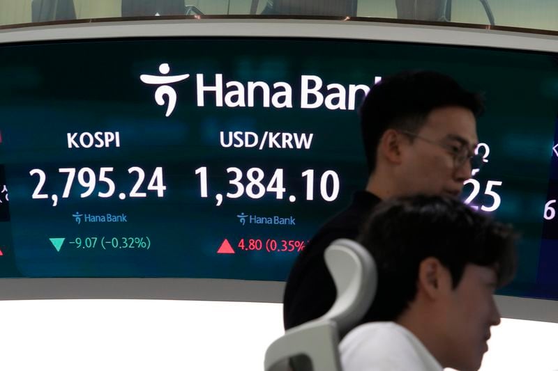 Currency traders watch monitors near the screen showing the Korea Composite Stock Price Index (KOSPI), left, and the foreign exchange rate between U.S. dollar and South Korean won at the foreign exchange dealing room of the KEB Hana Bank headquarters in Seoul, South Korea, Tuesday, July 2, 2024. (AP Photo/Ahn Young-joon)