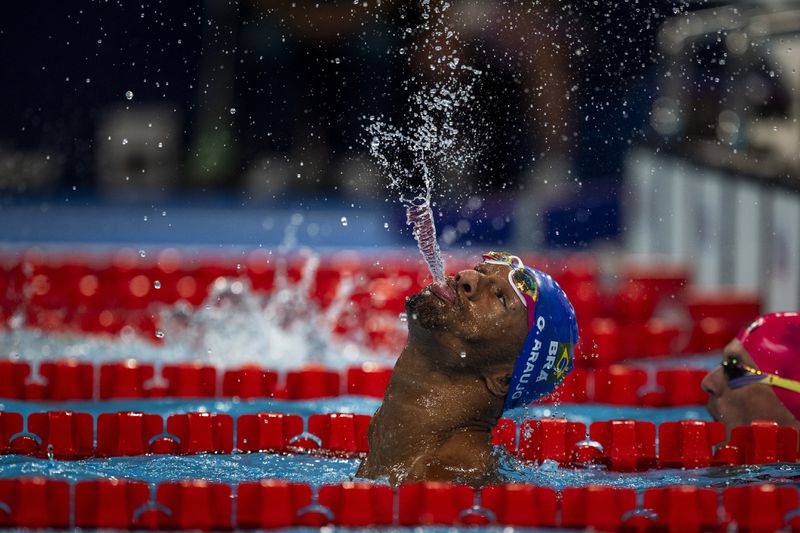 Paralympic athlete Araujo dos Santos, of Brasil, spits water to celebrate his victory at the Men's 100m backstroke -S2 final, during the 2024 Paralympics, Thursday, Aug. 29, 2024, in Paris, France. (AP Photo/Emilio Morenatti)