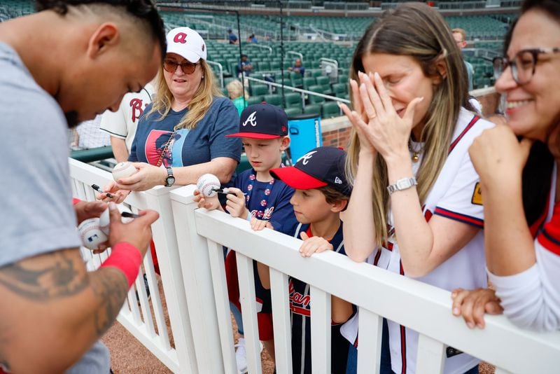 Leslie Tessler gets emotional as she sees Braves shortstop Orlando Arcia signing an autograph to her son Lucas Torino (8) before the game against the Chicago Cubs at Truist Park on Tuesday, May 14, 2024. 

(Miguel Martinez/ AJC)