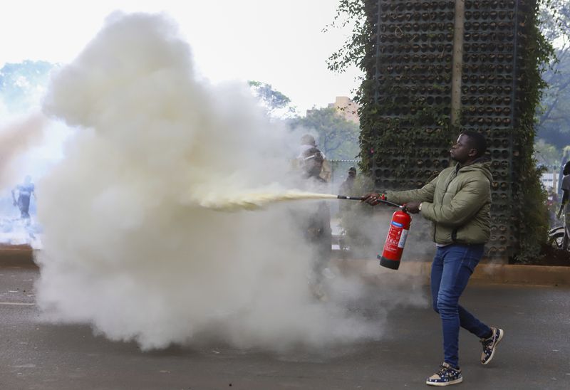 A protester uses a fire extinguisher during a protest over proposed tax hikes in a finance bill that is due to be tabled in parliament in Nairobi, Kenya, Thursday, June 20, 2024. (AP Photo/ Andrew Kasuku)