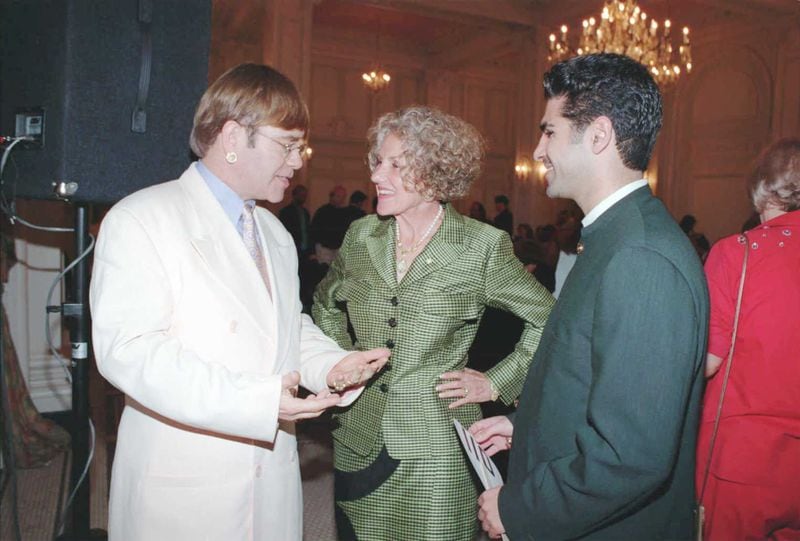 Fay Gold joined forces with Elton John (left), chairing two art auctions to raise money to fight AIDS. They are joined by Versace boutique manager Farshid Arshid (right) at John's 2013 AIDS fundraiser at the Georgian Terrace.