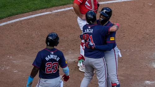 Atlanta Braves' Jorge Soler, right, embraces teammate Orlando Arcia, center, after hitting a 3-run home run during the sixth inning of a baseball game against the Cincinnati Reds, Thursday, Sept. 19, 2024, in Cincinnati. (AP Photo/Joshua A. Bickel)