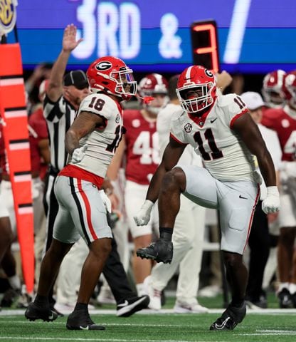 Georgia Bulldogs linebacker Jalon Walker (11) celebrates with linebacker Xavian Sorey Jr. (18) after tackling Alabama Crimson Tide quarterback Jalen Milroe during the first half of the SEC Championship football game at the Mercedes-Benz Stadium in Atlanta, on Saturday, December 2, 2023. (Jason Getz / Jason.Getz@ajc.com)