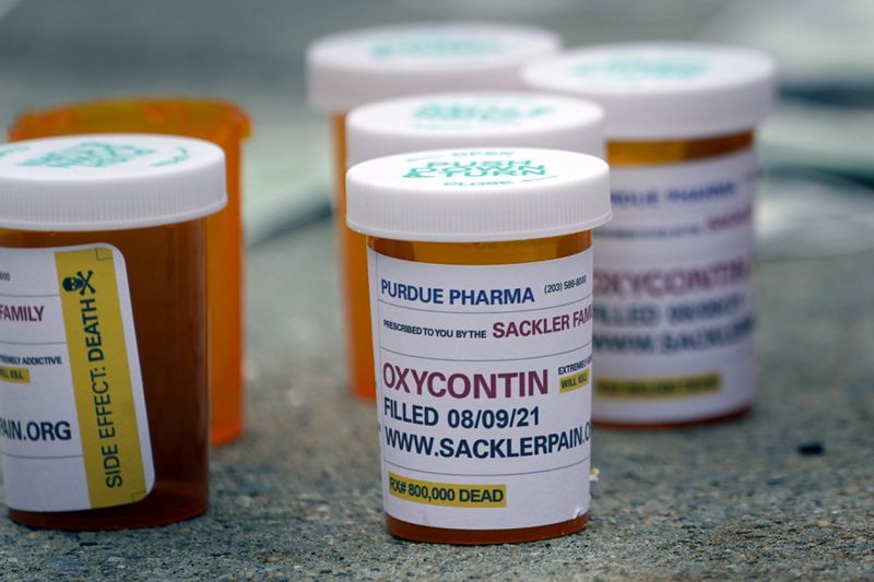 FILE - Fake pill bottles with messages about Purdue Pharma are displayed during a protest outside the courthouse where the bankruptcy of the company is taking place in White Plains, N.Y., Monday, Aug. 9, 2021. The Supreme Court on Thursday, June 27, 2024, rejected a nationwide settlement with OxyContin maker Purdue Pharma that would have shielded members of the Sackler family who own the company from civil lawsuits over the toll of opioids but also would have provided billions of dollars to combat the opioid epidemic. (AP Photo/Seth Wenig, File)