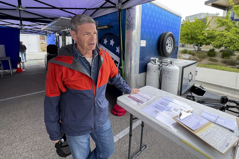 Poll worker David Wallace explains how ballots are distributed to Idaho voters based on their political party affiliation on Monday, May 6, 2024, in Boise, Idaho. Idaho's primary elections are currently closed – meaning residents generally must choose the ballots associated with the political party they have affiliated with – but a voter initiative is likely to be on the ballot this fall that could switch the state to open primaries and create a ranked-choice voting system. (AP Photo/Rebecca Boone)