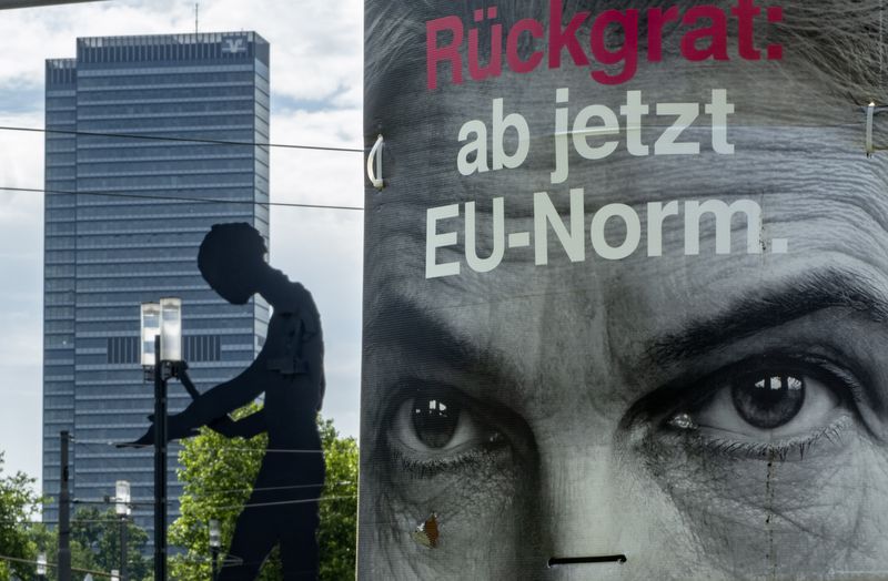 An election poster of Germany's Free Democratic Party's top candidate Marie-Agnes Strack-Zimmermann is fixed on a pole in Frankfurt, Germany, Wednesday, June 5, 2024. In background "the hammering man" a statue by US artist Jonathan Borofsky. Letters read "spine: from now on EU norm". (AP Photo/Michael Probst)