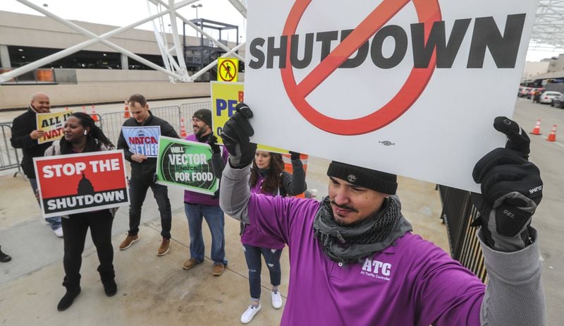 January 14, 2019 Atlanta: Air traffic controller, Rafael Naveira (right) and fellow controllers rallied at the north domestic terminal. Air Traffic controllers rallied and handed out leaflets to travelers on Monday Jan. 14, 2019 at Hartsfield-Jackson International Airport domestic terminals calling for an end to the federal shutdown. JOHN SPINK/JSPINK@AJC.COM