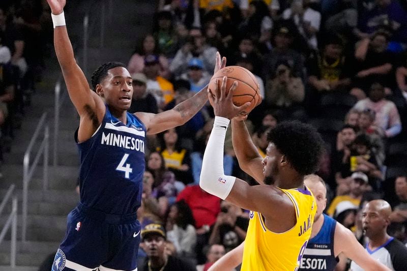 Los Angeles Lakers guard Bronny James, right, tries to shoot as Minnesota Timberwolves guard Rob Dillingham defends during the first half of a preseason NBA basketball game, Friday, Oct. 4, 2024, in Palm Desert, Calif. (AP Photo/Mark J. Terrill)