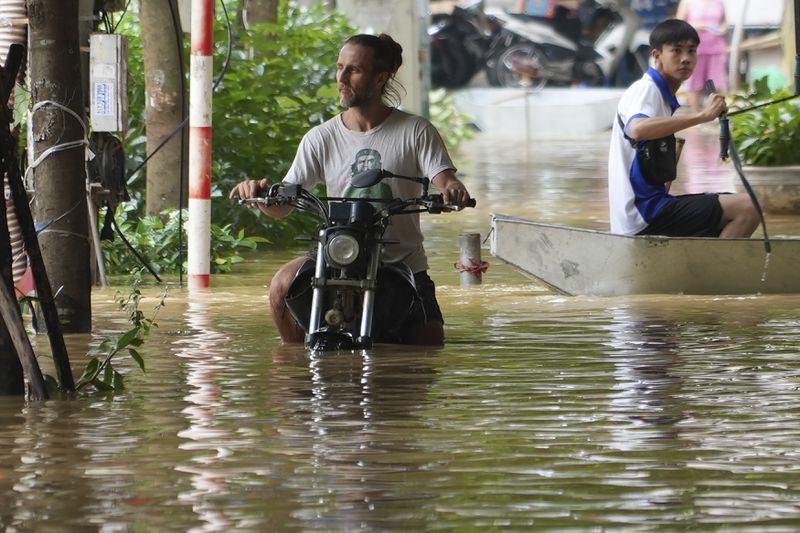 A man pushes his motorbike in a flooded street in the aftermath of Typhoon Yagi, in Hanoi, Vietnam on Thursday, Sept. 12, 2024. (AP Photo/Hau Dinh)