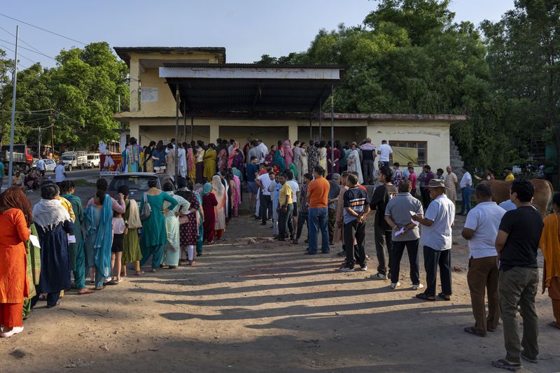 People stand in queues to vote in the seventh and last round of polling in India's national election in Dharamshala, India, Saturday, June 1, 2024. (AP Photo/Ashwini Bhatia)