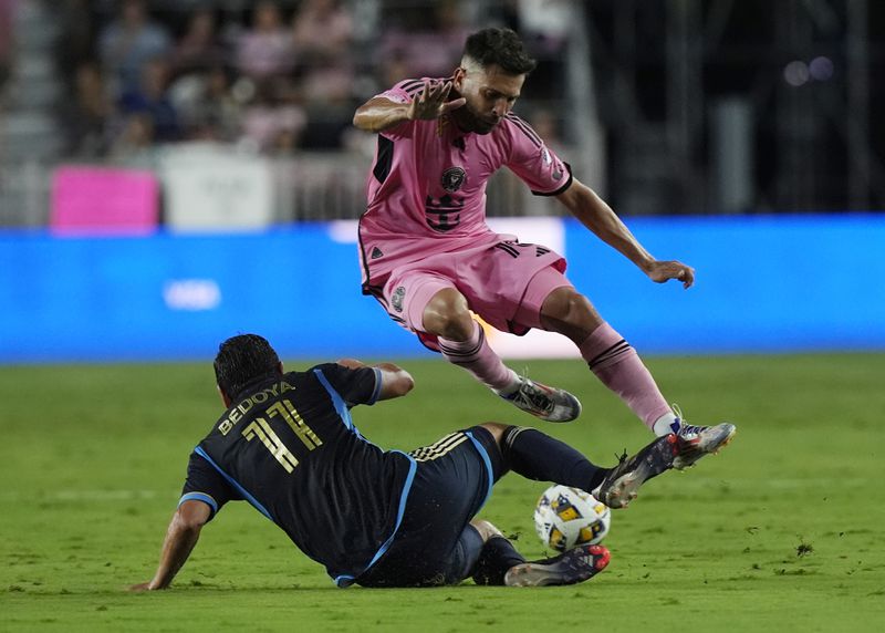 Inter Miami defender Jordi Alba (18) jumps over Philadelphia Union midfielder Alejandro Bedoya (11) during the second half of an MLS soccer match, Saturday, Sept. 14, 2024, in Fort Lauderdale, Fla. (AP Photo/Marta Lavandier)