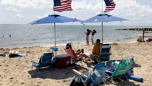 People fly the American flag on their beach umbrellas, Friday, Aug. 30, 2024, in Dennis Port, Mass. (AP Photo/Michael Dwyer)