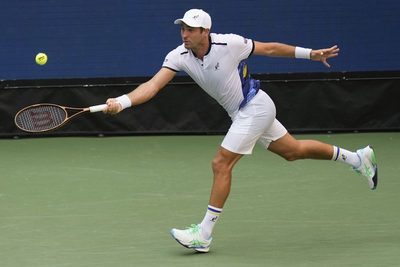 Dusan Lajovic, of Serbia, returns a shot to Daniil Medvedev, of Russia, during the first round of the U.S. Open tennis championships, Tuesday, Aug. 27, 2024, in New York. (AP Photo/Seth Wenig)