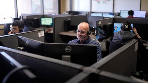 Customer Experience Representatives Stanley Solis, center, and other representatives take calls at an Alorica center, Monday, Aug. 19, 2024, in San Antonio. (AP Photo/Eric Gay)