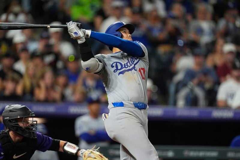 Los Angeles Dodgers' Shohei Ohtani follows the flight of his three-run home run off Colorado Rockies relief pitcher Anthony Molina in the sixth inning of a baseball game, Friday, Sept. 27, 2024, in Denver. (AP Photo/David Zalubowski)