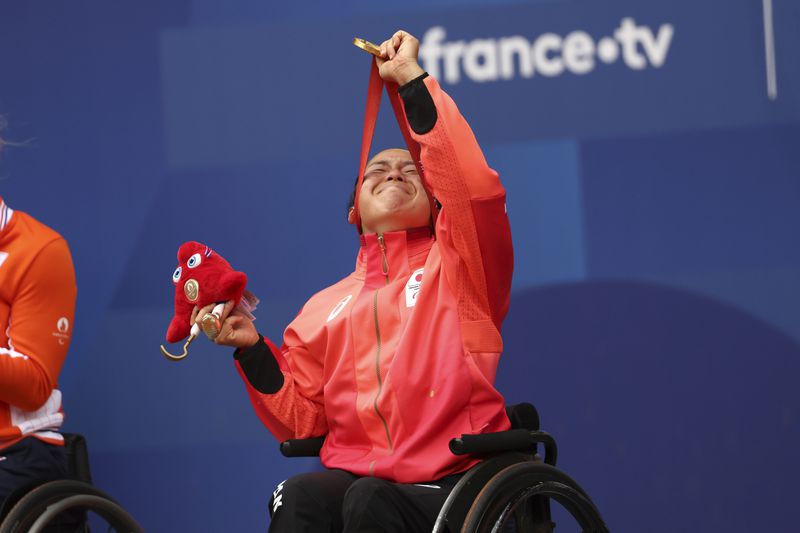 Japan's Yui Kamiji reacts with her gold medal after winning the Women's Singles Wheelchair Tennis at the 2024 Paralympics, on Friday, Sept. 6, 2024 in Paris, France. (AP Photo/Caleb Craig)