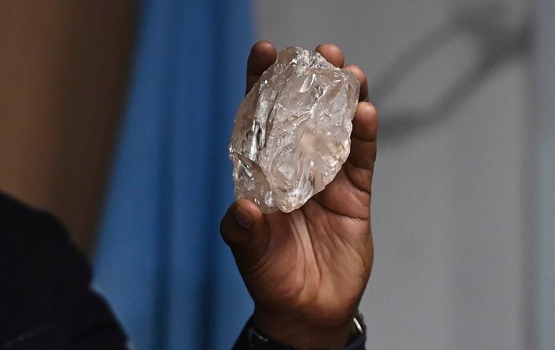 A person holds a 2,492-carat diamond which was found in the country and on show, in Gaborone, Botswana, Thursday, Aug. 22, 2024. (AP Photo)