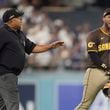 San Diego Padres left fielder Jurickson Profar, right, talks to umpire Adrian Johnson after items were thrown at Profar in the outfield during the seventh inning in Game 2 of a baseball NL Division Series against the Los Angeles Dodgers, Sunday, Oct. 6, 2024, in Los Angeles. (AP Photo/Ashley Landis)